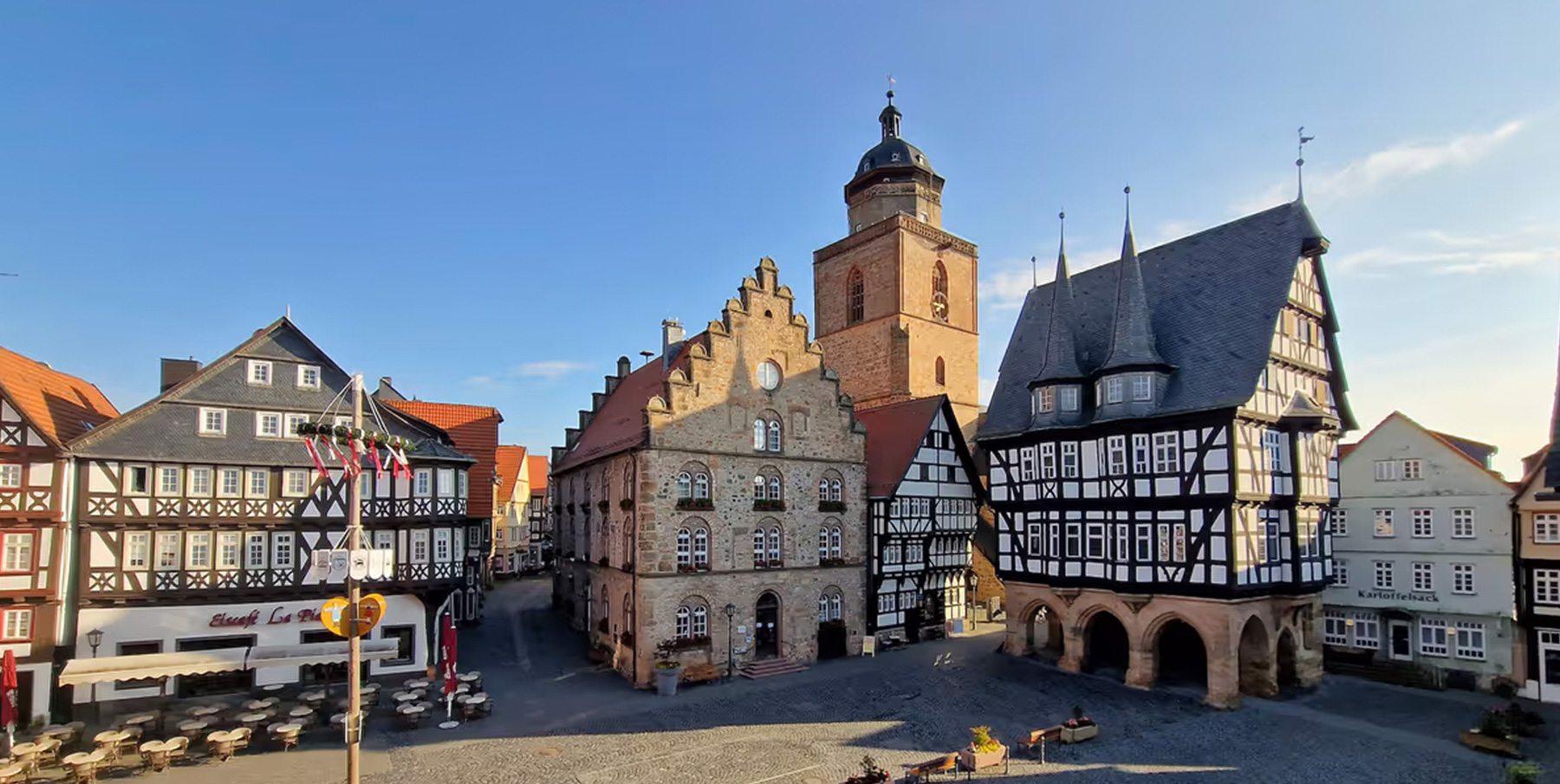 Blick auf den Alsfelder Marktplatz mit dem Fachwerk-Rathaus rechts, dem Weinhaus mit Staffelgiebel in der Mitte und dem Turm der Walpurgiskirche dahinter