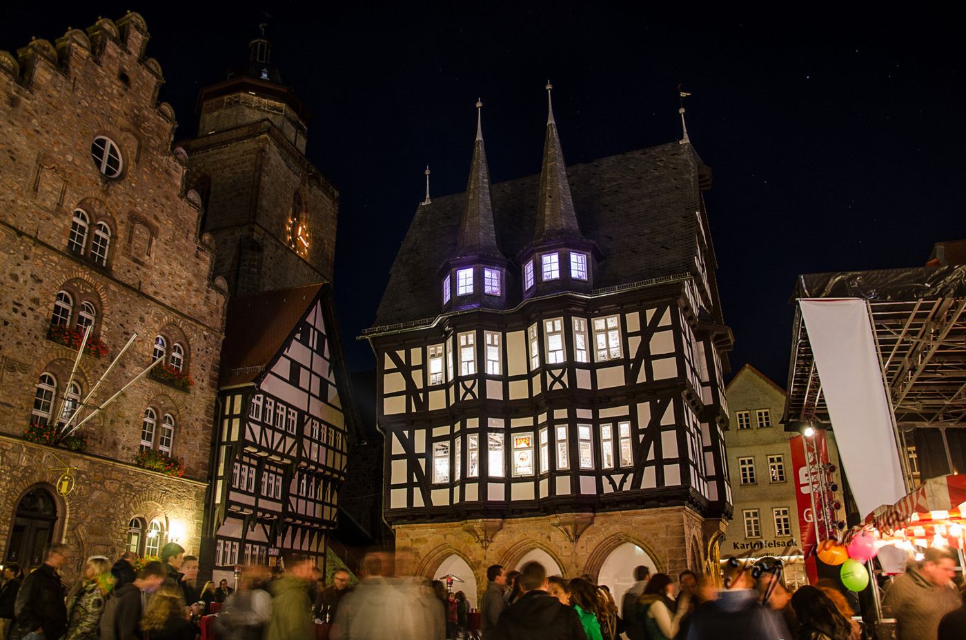 Das Alsfelder Rathaus am Abend, davor Marktbuden und Besucher auf dem Marktplatz